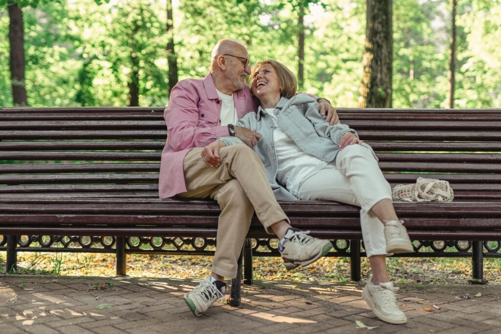 elderly couple sitting on a bench at a park
