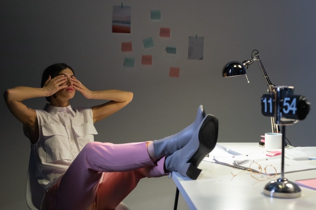 a lady sitting at desk closing her eyes