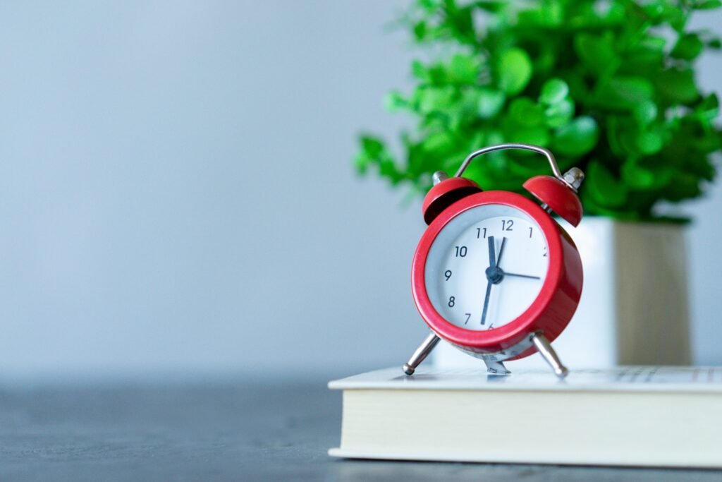 a red alarm clock on table